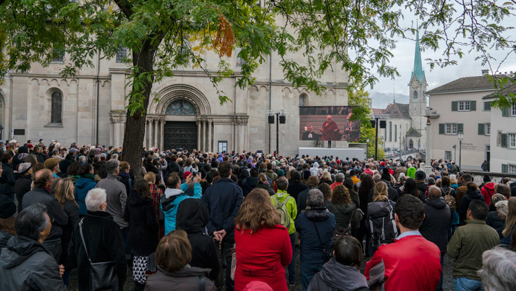 グロスミュンスター大聖堂の外に取り付けられた大型モニターを通して、世界平和祈念式典の様子を見つめる700人を超える人々。2016年10月15日、スイス、チューリッヒ（撮影：テンジン・チュンジョル / 法王庁）