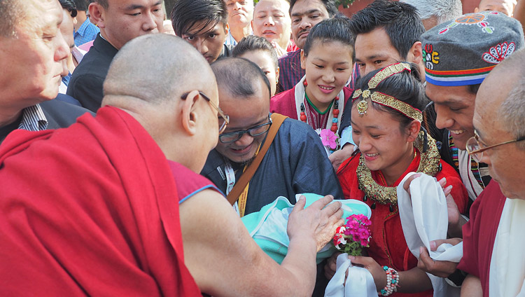 高等チベット学中央研究所に到着されたダライ・ラマ法王に、生まれたばかりの赤ん坊にお加持を求める若いチベット人の夫婦。2018年3月19日、インド、ウッタル・プラデーシュ州バラナシ、サールナート（撮影：ジェレミー・ラッセル / 法王庁）