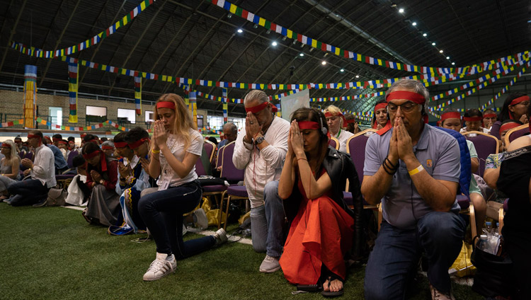 儀式用の目隠しをつけてダライ・ラマ法王から観音菩薩の灌頂を授かる受者たち。2018年6月18日、ラトビア、リガ（撮影：テンジン・チョンジョル / 法王庁）