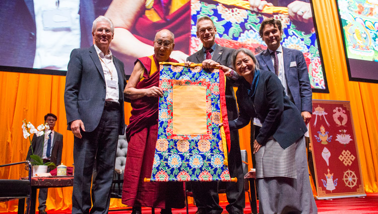 チベットのための国際キャンペーン（ICT）からダライ・ラマ高等教育大学に贈与される補助金の証書を掲げるダライ・ラマ法王とICTのメンバー。2018年9月16日、オランダ、ロッテルダム（撮影：ユルイェン・ヨンカース）