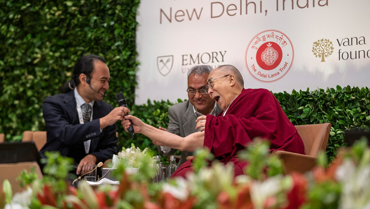 パネルディスカッションで、ブレンダン・オザワ・デ・シルバ教授に茶目っ気たっぷりにマイクを渡されるダライ・ラマ法王。2019年4月5日、インド、ニューデリー（撮影：テンジン・チュンジョル / 法王庁）