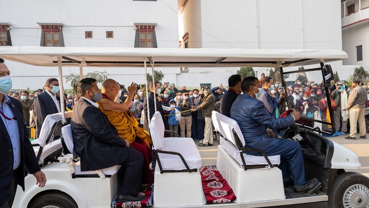 カーラチャクラグラウンドまでの道すがら、道の両側に並んで法王を待つ人々に手を振られるダライ・ラマ法王。2022年12月29日、インド、ビハール州ブッダガヤ（撮影：テンジン・チュンジョル / 法王庁）