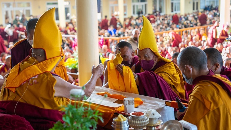 ツクラカンの中庭で、法話のはじめに仏陀の身口意の三つの象徴を捧げるガンデン僧院座主。2023年3月7日、インド、ヒマーチャル・プラデーシュ州ダラムサラ（撮影：テンジン・チュンジョル / 法王庁）