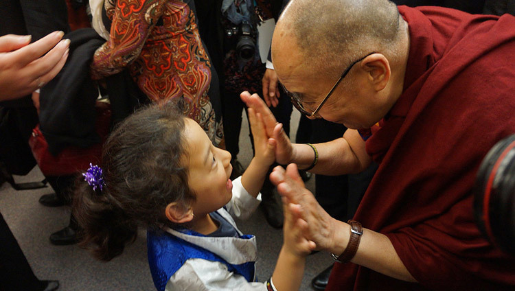 ジョン・オリバー・スクール出発の際に、チベット人の少女に挨拶されるダライ・ラマ法王。2014年10月21日、カナダ、バンクーバー（撮影：ジェレミー･ラッセル / 法王庁）