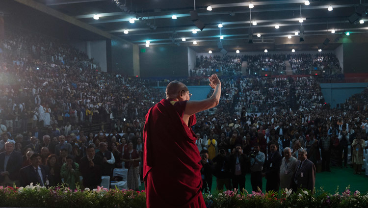 講演会場のタヤガラージ・スタジアムに到着され、聴衆席の参加者たちに手を振って挨拶をされるダライ・ラマ法王。2016年12月9日、インド、ニューデリー（撮影：テンジン・チュンジョル / 法王庁）