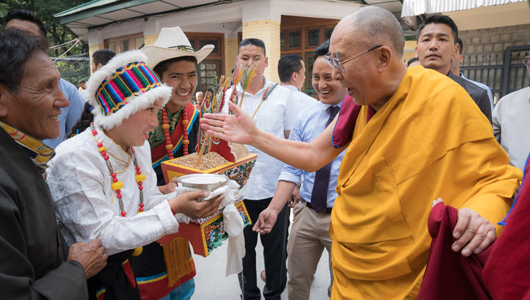 3日間にわたるチベット人の若者たちに向けた法話会初日、ダライ・ラマ法王をツクラカンの中庭で出迎え、伝統的な供物を捧げるTCVの生徒たち。2017年6月5日、インド、ヒマーチャル・プラデーシュ州ダラムサラ（撮影：テンジン・チュンジョル / 法王庁）