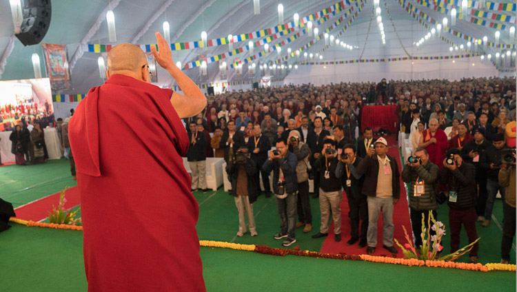 高等チベット学中央研究所で開催された「インド哲学諸学派の心についての見解と現代科学の会議」の会場に到着され、聴衆に手を振られるダライ・ラマ法王。2017年12月30日、インド、ウッタル・プラデーシュ州バラナシ、サールナート（撮影：ロブサン・ツェリン / 法王庁）