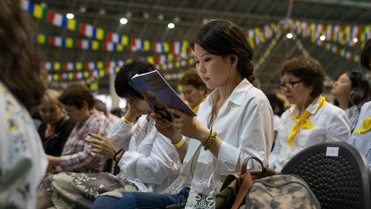 ダライ・ラマ法王が読み上げられるテキストをともに目で追う参加者たち。2018年6月17日、ラトビア、リガ（撮影：テンジン・チュンジョル / 法王庁）