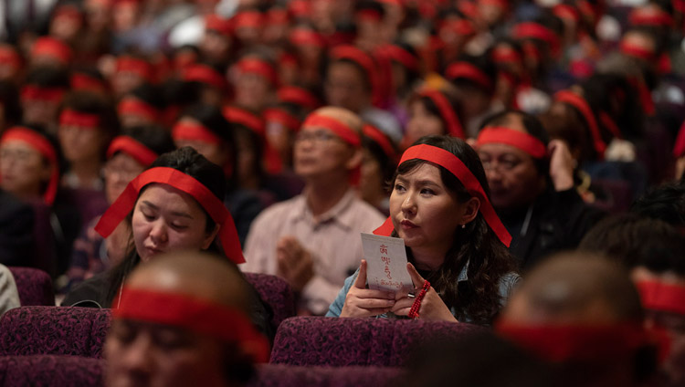 観世音世間自在の灌頂授与の儀式の中で、赤い目隠しをつける受者たち。2018年11月15日、横浜（撮影：テンジン・チュンジョル / 法王庁）