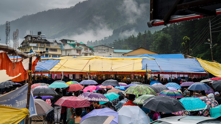 ダライ・ラマ法王による大悲世自在観音の灌頂伝授会で、雨に打たれる会場の情景。聴衆の一部は傘をさしての参加となった。2019年8月17日、インド、ヒマーチャル・プラデーシュ州マナリ（撮影：テンジン・チュンジョル / 法王庁）