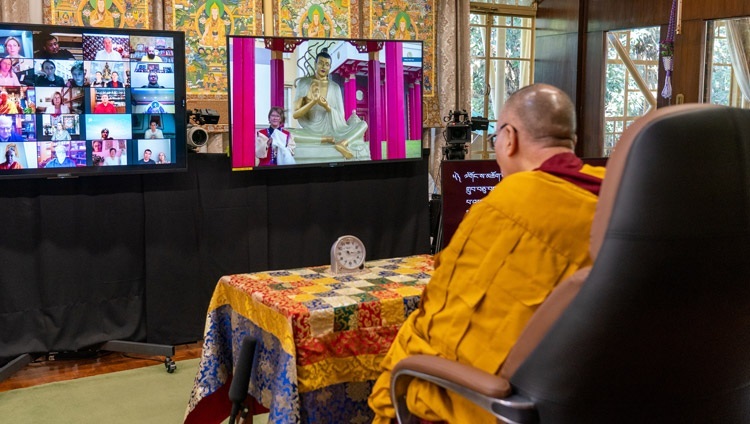 法王公邸からの法話会3日目、カルムイク共和国の中央仏教僧院 “釈迦牟尼仏の黄金の住居” の外に建立されたナーガールジュナ像のそばに立ち、ダライ・ラマ法王に質問をするモニター上の参加者。2020年11月7日、インド、ヒマーチャル・プラデーシュ州ダラムサラ（撮影：テンジン・ジャンペル / 法王庁）