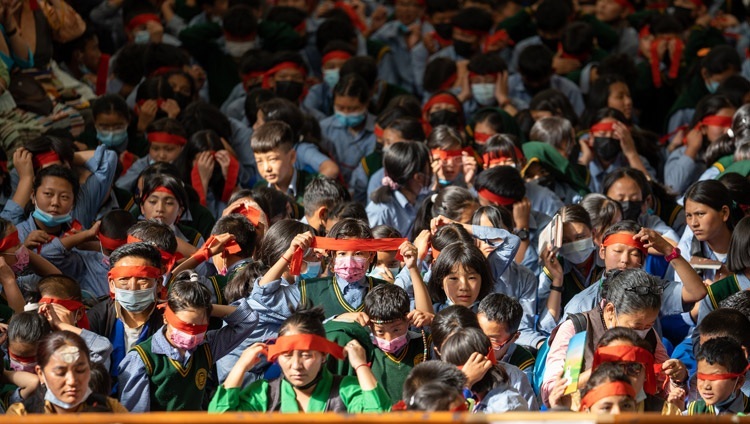 ダライ・ラマ法王が授与される千手千眼観音菩薩の灌頂の一環で、儀式用の赤い目隠しをつけた学生たち。2022年6月2日（撮影：テンジン・チュンジョル / 法王庁）
