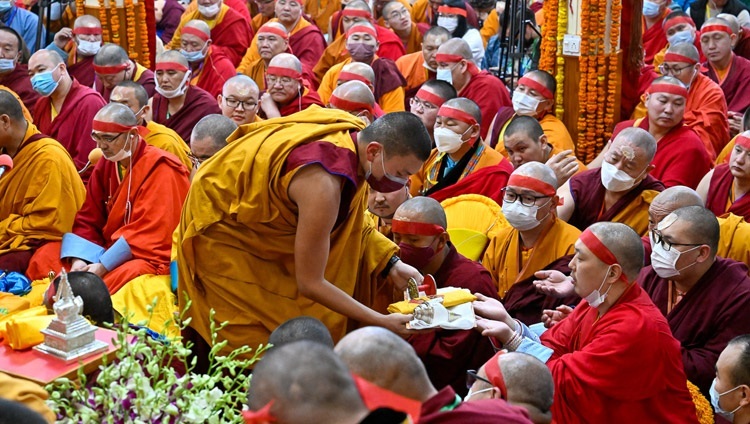 受者たちがチャクラサンヴァラの灌頂の小物に触れられるように、参加者の間を縫って歩く僧侶たち。2023年3月9日、インド、ヒマーチャル・プラデーシュ州ダラムサラ（撮影：ザムリン・ノルブ / 法王庁）