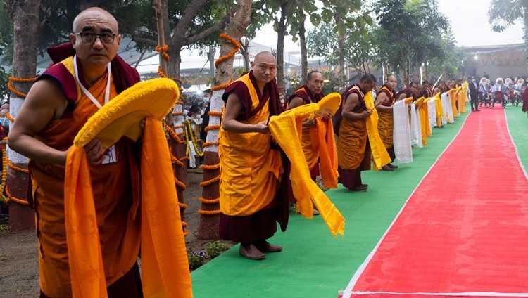 カーラチャクラ・グラウンドへの沿道に並んで、長寿祈願法要に出席されるダライ・ラマ法王の到着を待つ僧侶たち。2024年1月1日、インド、ビハール州ブッダガヤ（撮影：テンジン・チュンジョル / 法王庁）